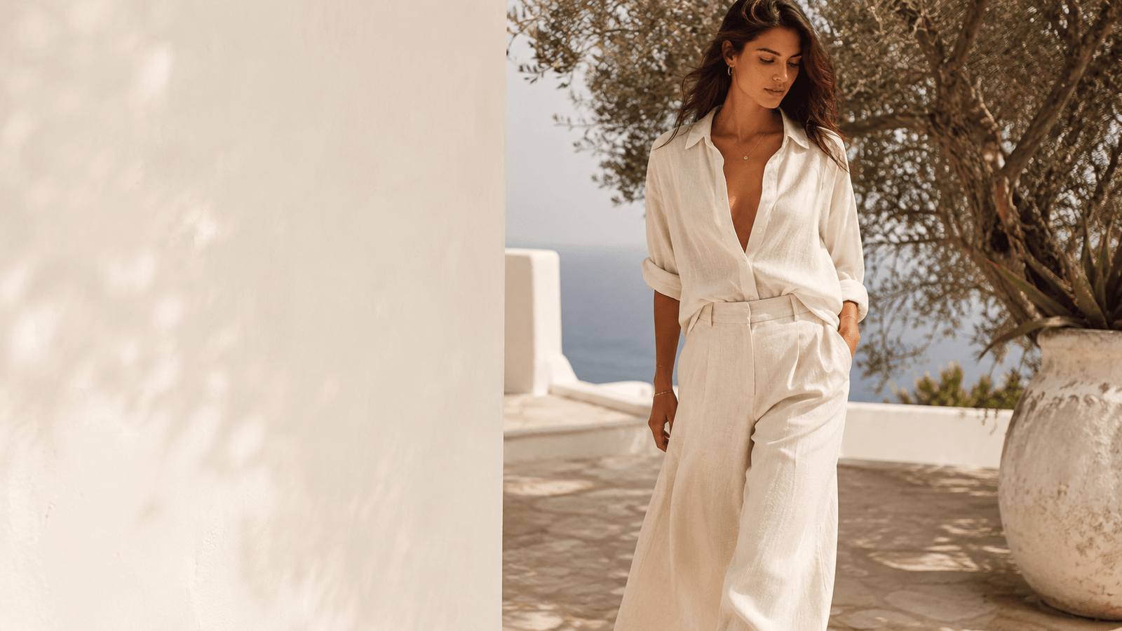 Summer Collection For Women — ivory linen co-ord on a sunlit Mediterranean terrace, quiet luxury resort editorial